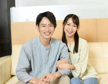 カップルが腕を組みあってがこちらを向いている様子